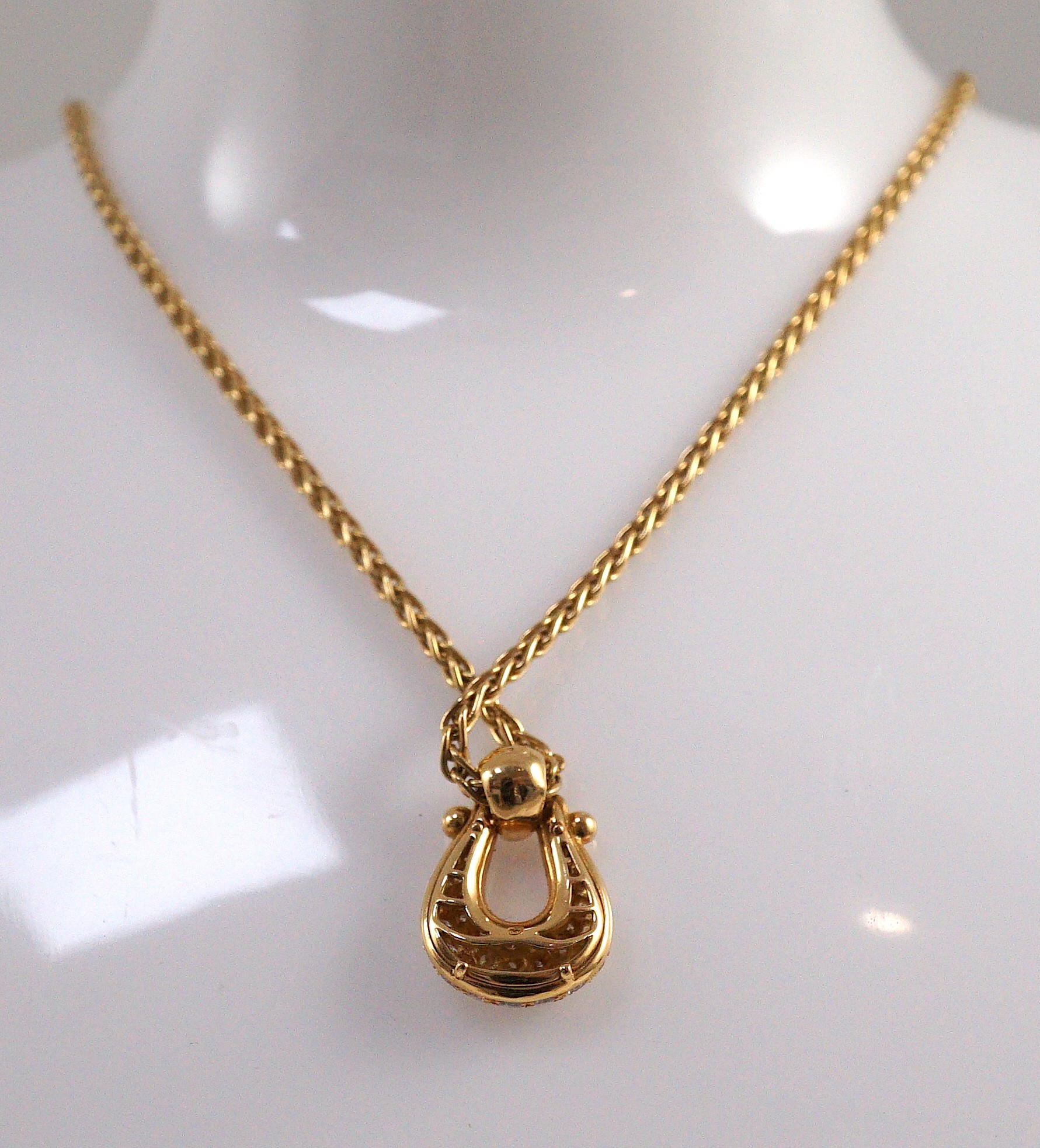 A modern French 18ct gold and pave set diamond 'U' shaped pendant, on a French 18ct gold chain